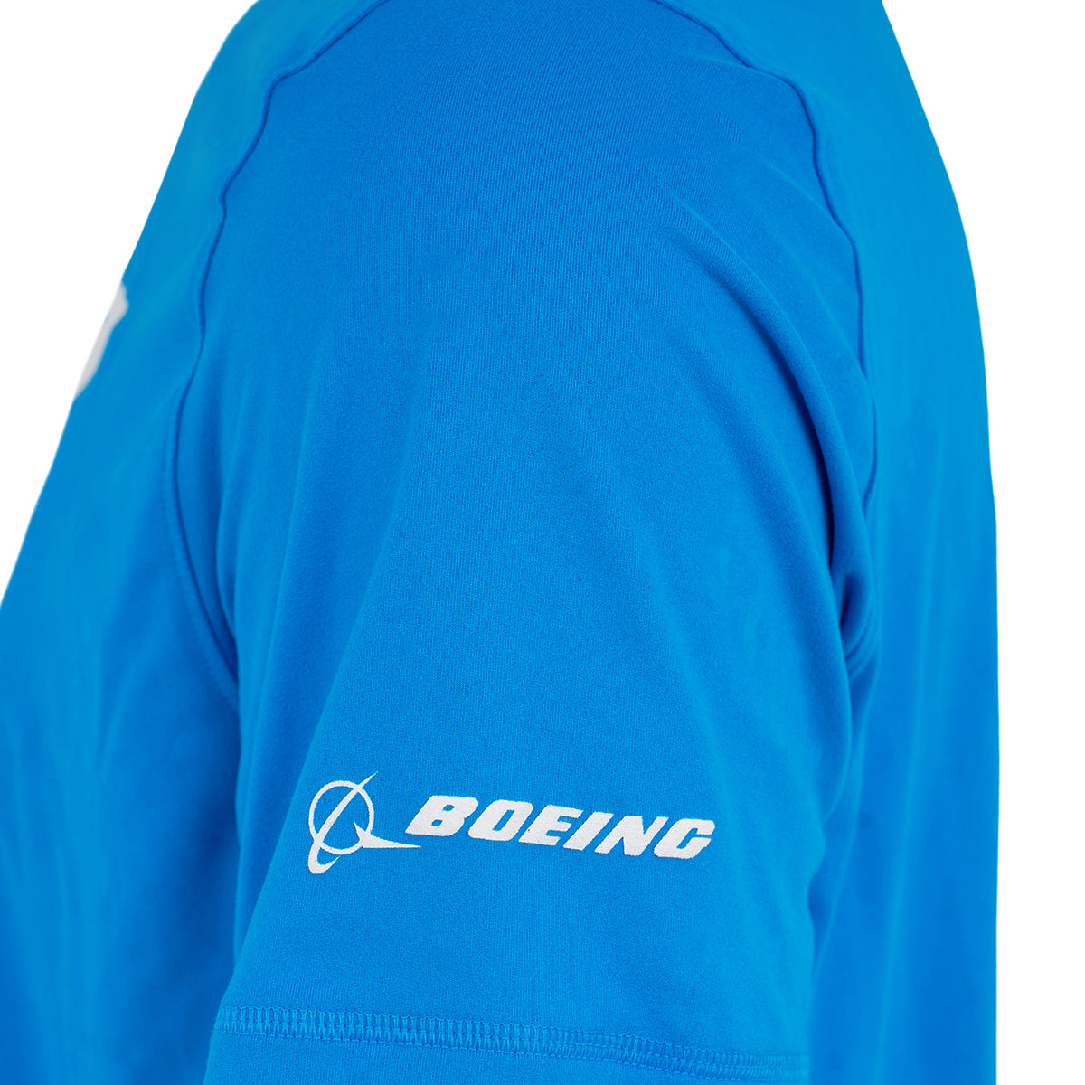 A person wears the Boeing 777X Velocity Unisex Tech Stretch T-Shirt by BOEING, in bright blue with the logo and name in white on the sleeve, featuring an athletic fit and moisture-wicking fabric for comfort.