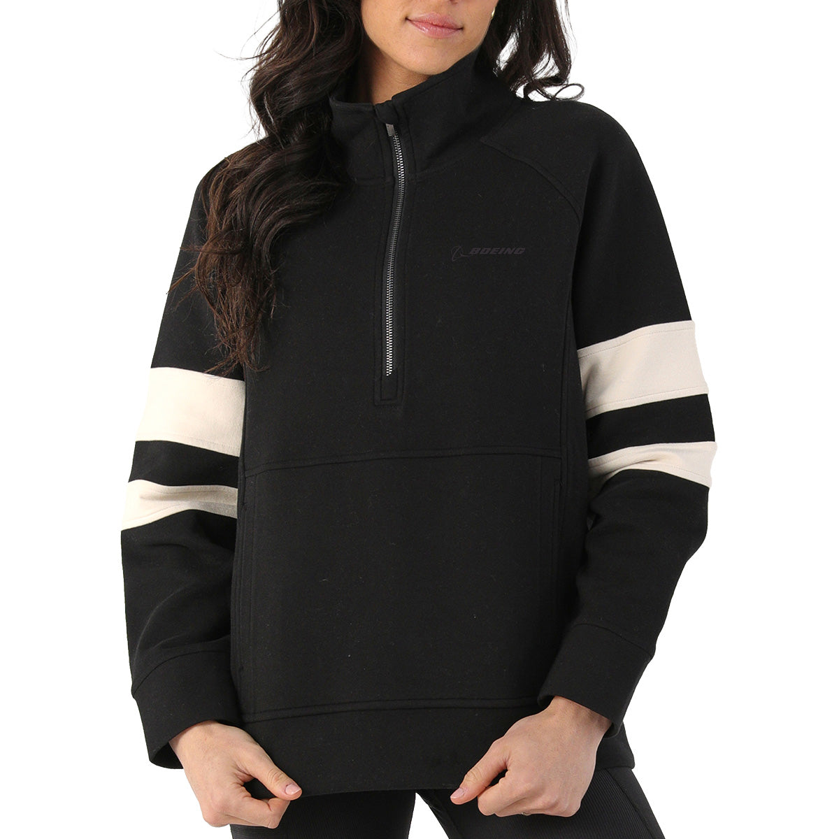 A woman models the BOEING Glyder Boeing Women’s Prodigious Scuba Quarter-Zip, a black pullover with white sleeve stripes, high collar, and relaxed oversized fit. She stands with hands crossed; the image is cropped above her knees.
