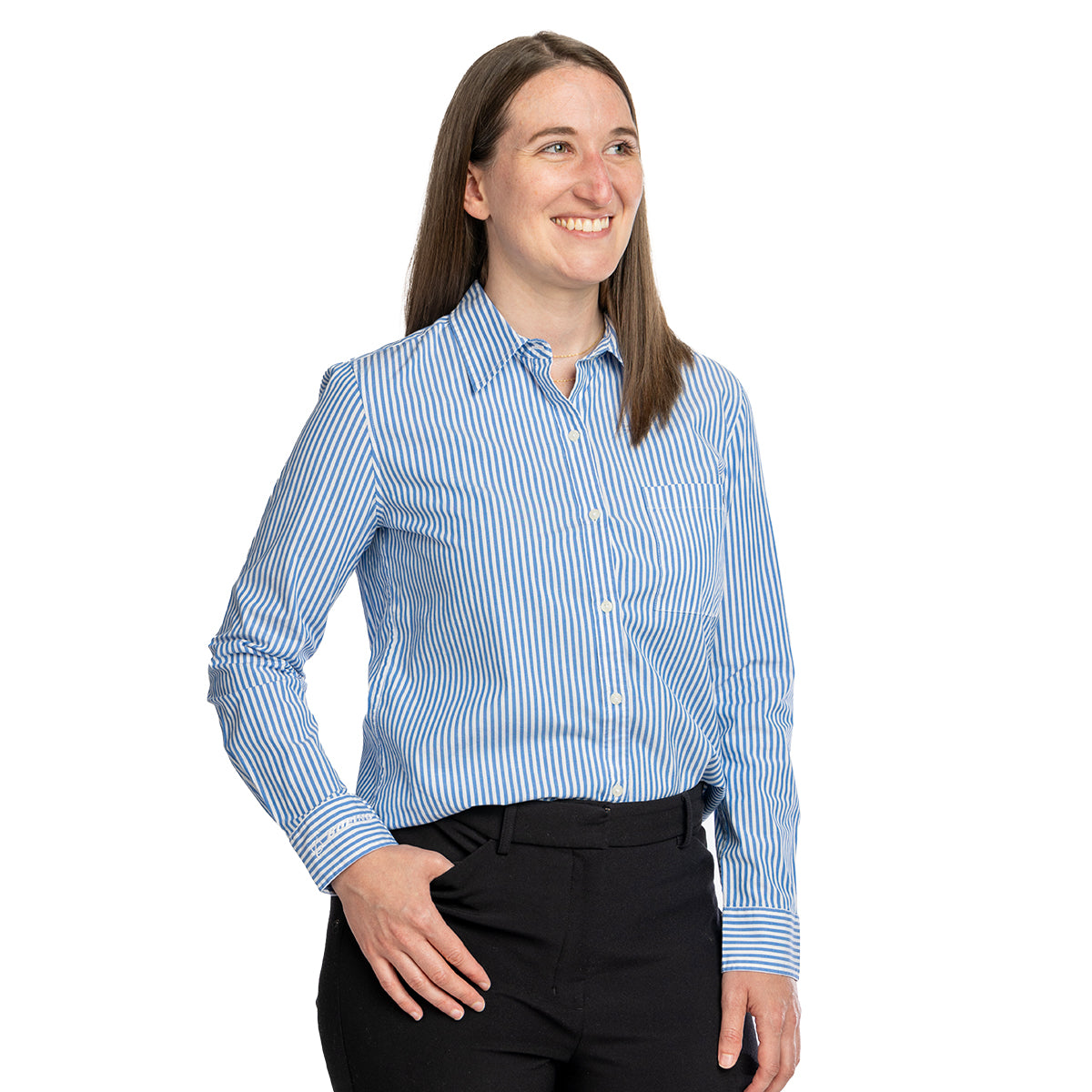 A smiling woman with straight brown hair wears the Boeing Vineyard Vines Bayview Womens Button-Down Shirt and black pants, standing against a plain white background.