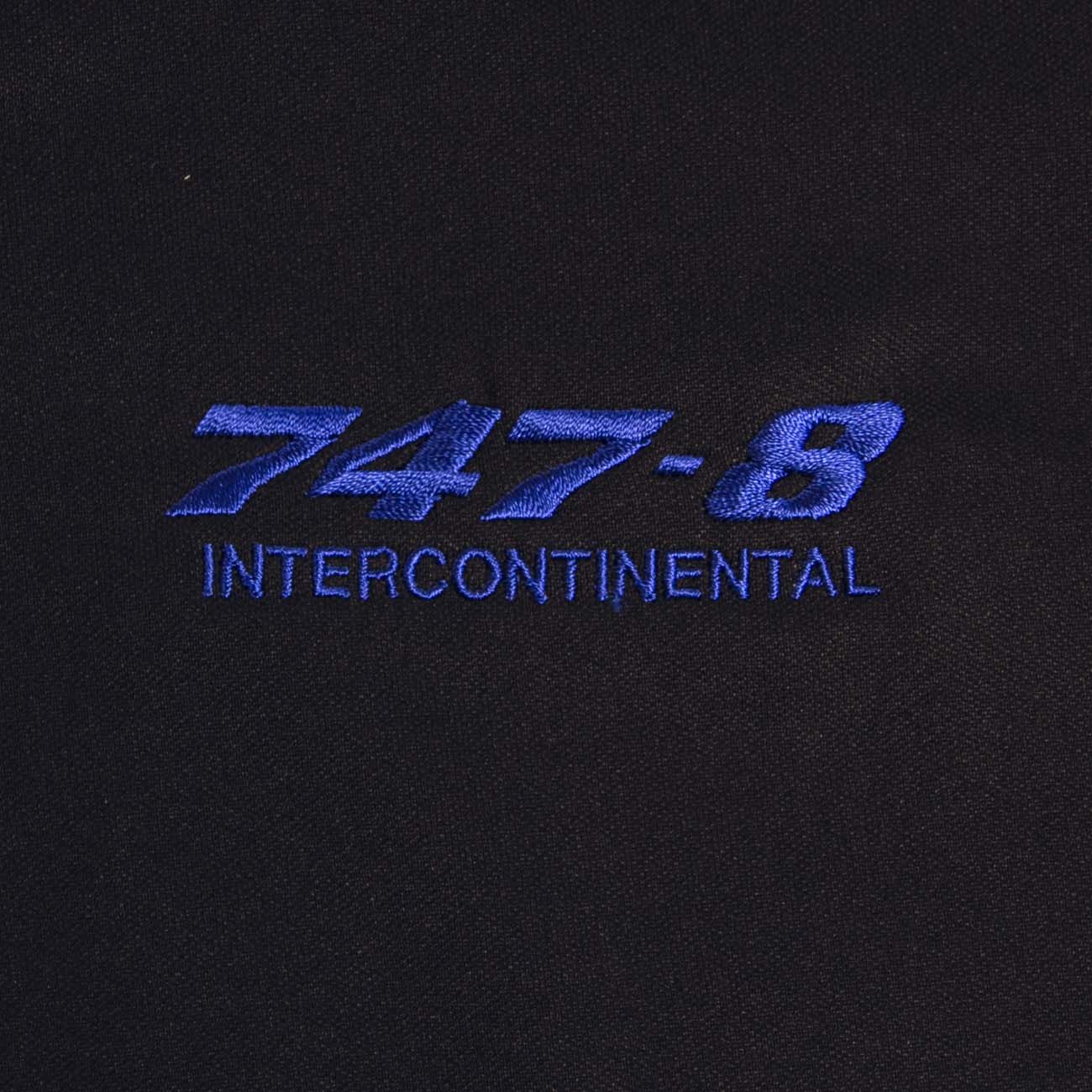 The image shows 747-8 INTERCONTINENTAL embroidered in blue on black fabric, part of a Boeing 747 Polo by The Boeing Store, noted for moisture-wicking and UV protection.