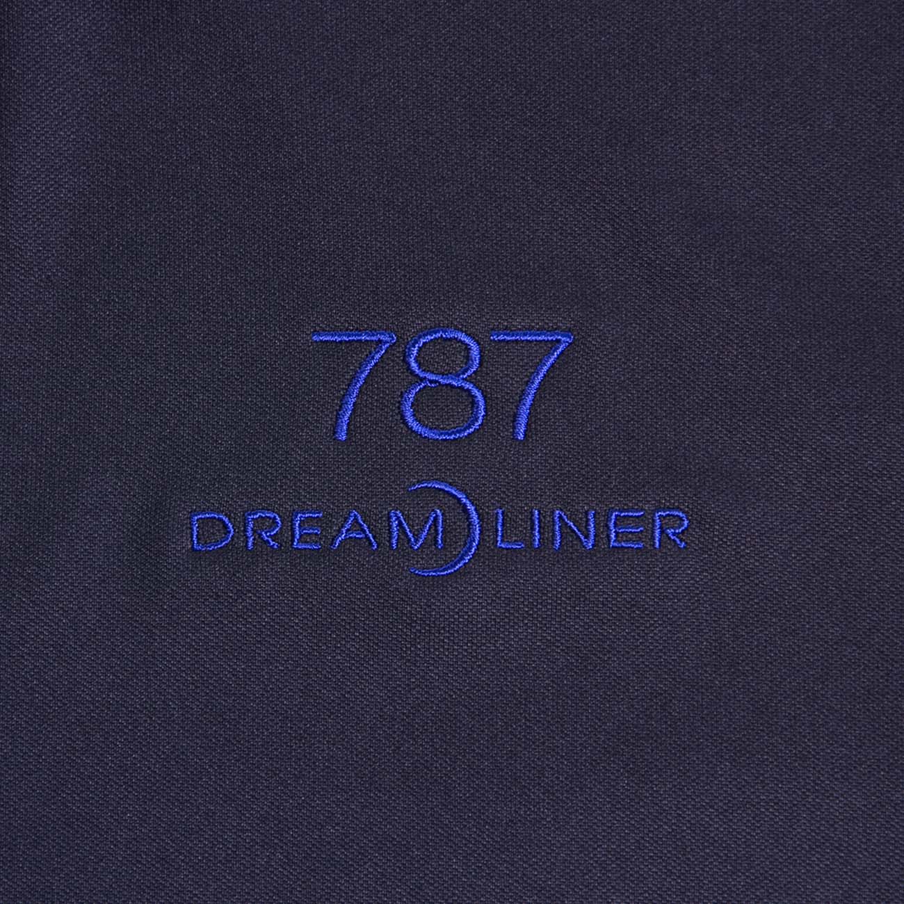 The Boeing Stores Boeing 787 Polo is a dark, moisture-wicking shirt featuring blue 787 Dreamliner embroidery with a stylized crescent moon incorporated into the text, designed under the Boeing program.