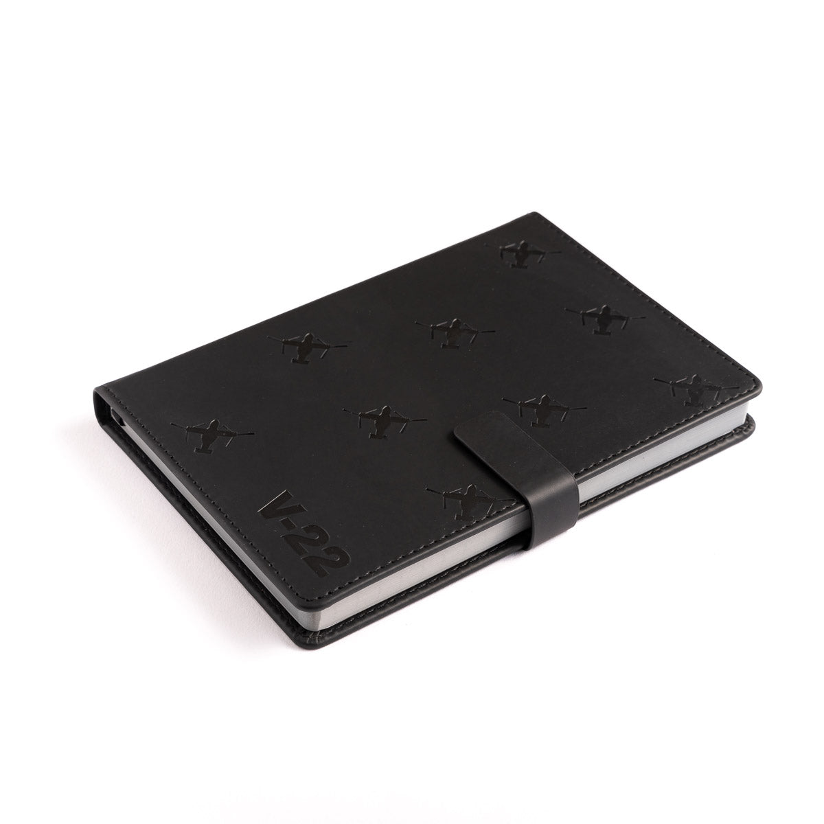 The Boeing Stores Boeing V-22 Osprey Notebook features a black PU hardcover, magnetic strap closure, embossed X shapes, and V-22 text in the bottom left corner, displayed on a white background.