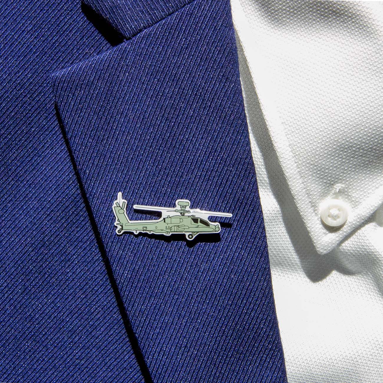 The Boeing Illustrated AH-64 Lapel Pin from The Boeing Store, featuring a silver-tone helicopter shape with an epoxy finish, adorns the blue textured suit lapel and complements the white shirt with visible buttons.