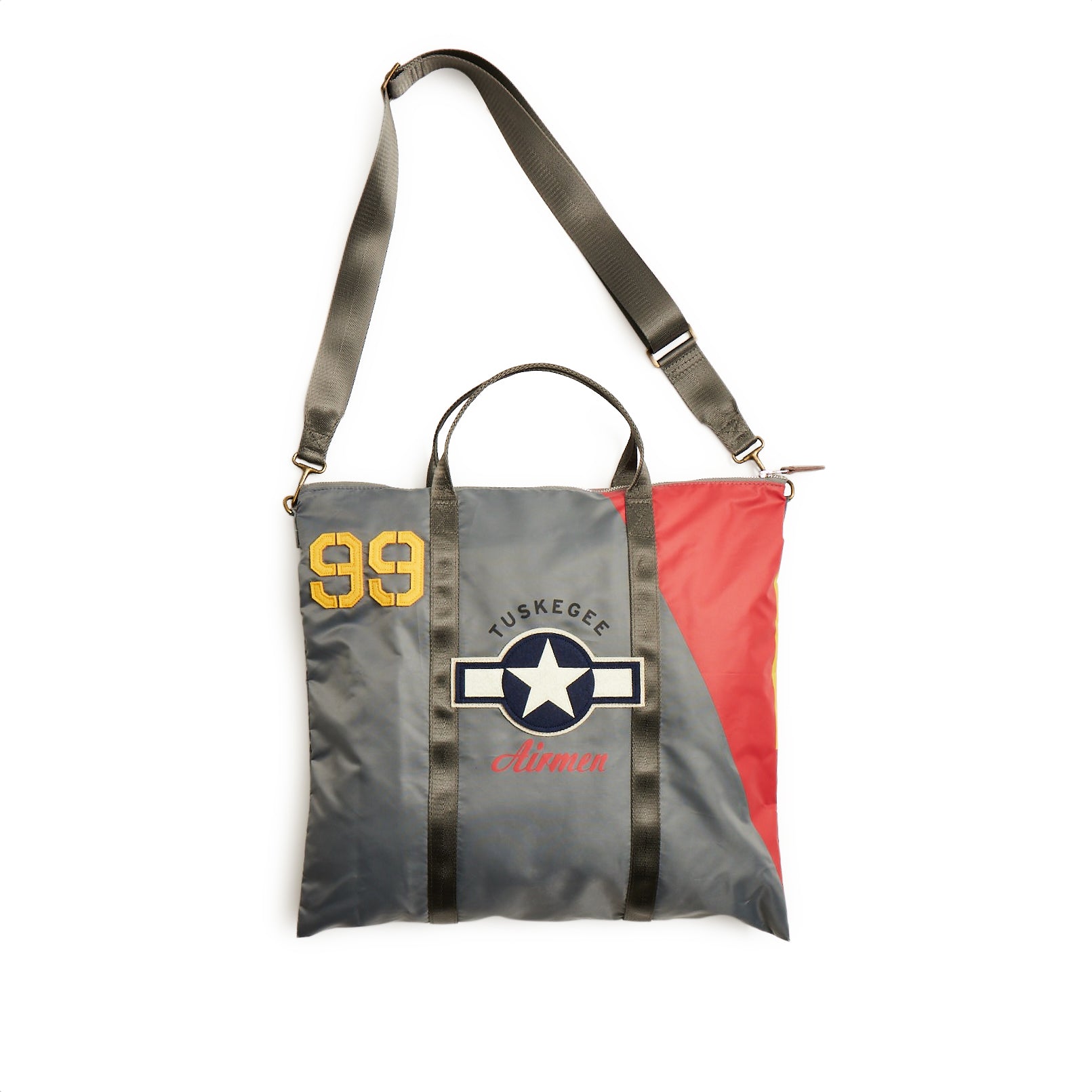 The The Boeing Stores Red Canoe Tuskegee Helmet Bag features a Tuskegee Airmen design with 99 in yellow, a star insignia, and colors of grey, red, and yellow. It includes YKK zippers, an adjustable shoulder strap, and short handles for versatile carrying.