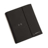 The Boeing Stores sleek, black faux leather Boeing Large Padfolio With Wireless Power Bank boasts a magnetic flap, wireless charging symbol in the center, and a subtle Boeing logo in the bottom-right corner, offering a smooth and professional finish that combines style with functionality.