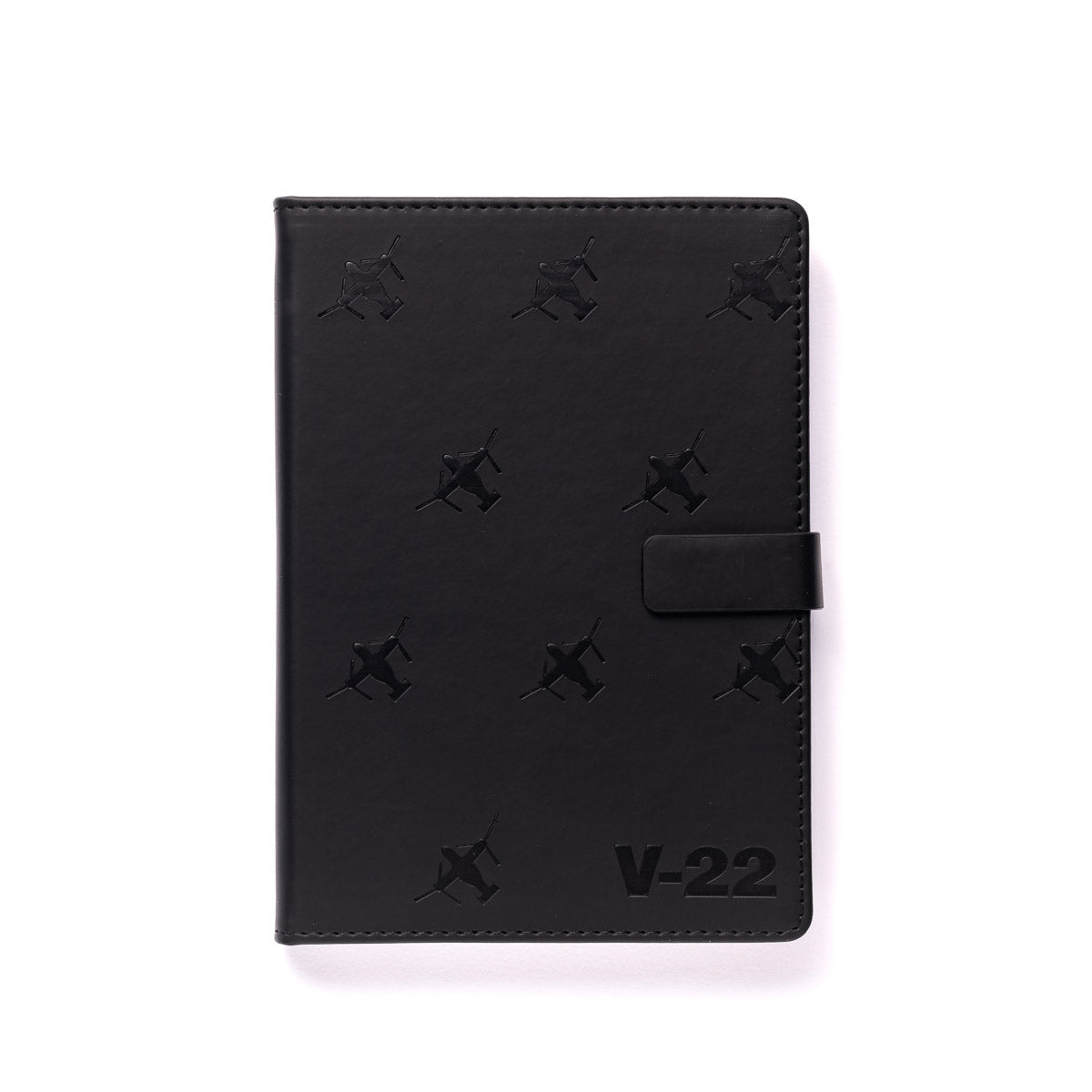 The Boeing Stores Boeing V-22 Osprey Notebook features a black PU hardcover with snap closure, stamped with small V-22 Osprey patterns and V-22 at the bottom right on a white background—ideal for any Boeing notebook fan.