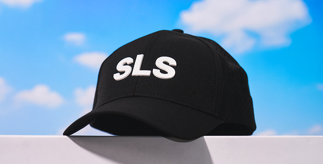 Boeing SLS Series Hat with logo on front against a bright blue sky with clouds.