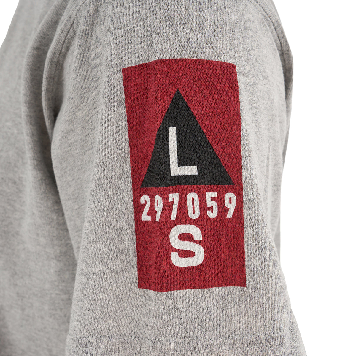 A close-up of a gray Red Canoe Boeing Airplane Company Logo B-17 T-Shirt sleeve from The Boeing Store, featuring a red patch with a black triangle, white L and S letters, and the number 297059 in bold white text.