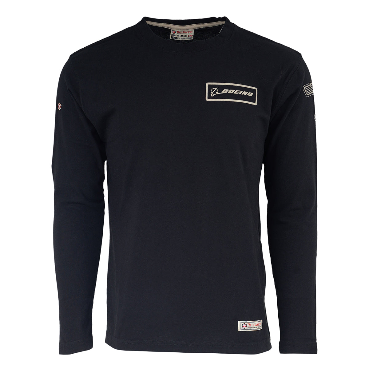 The Boeing Store’s Red Canoe Boeing Long Sleeve T-Shirt in black features a Boeing logo patch on the left chest, small right-sleeve patch, American flag on left sleeve, and a tag at the bottom hem.