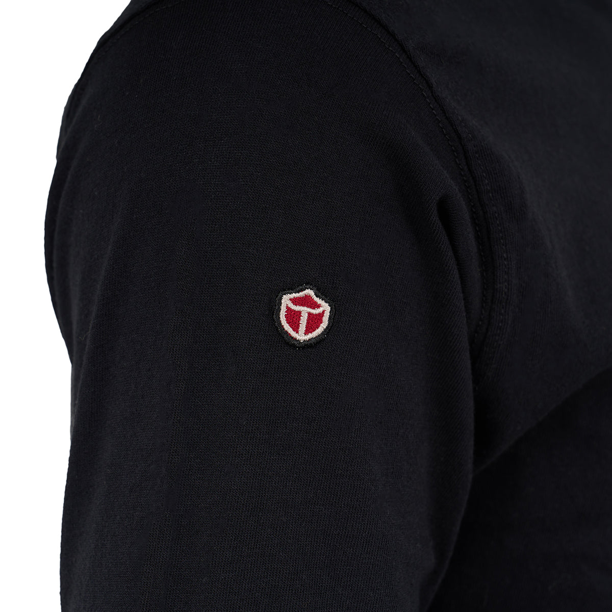 A close-up of a person wearing the Red Canoe Boeing Long Sleeve T-Shirt from The Boeing Store, featuring a small red and white shield-shaped Red Canoe logo on the upper arm.