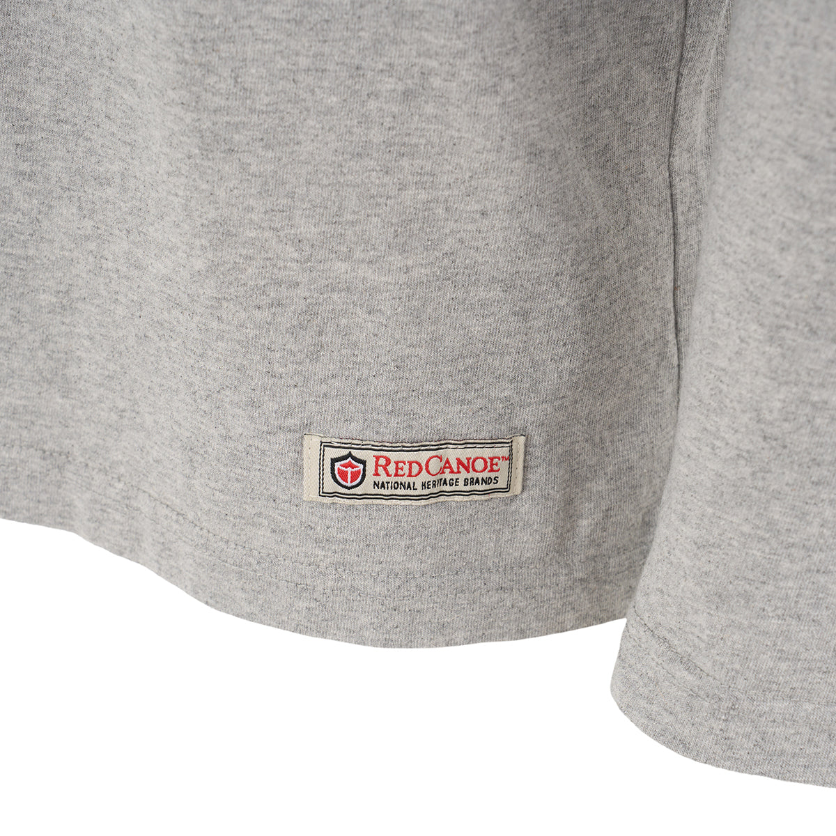 Close-up of a light gray Red Canoe NASA Long Sleeve T-Shirt by The Boeing Store, with a small rectangular label sewn near the hem.