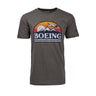 Boeing Horizon Mens T-Shirt features a gray design with a vivid graphic of a plane soaring over mountains at sunset, complete with the Boeing logo, embodying the aviation spirit.