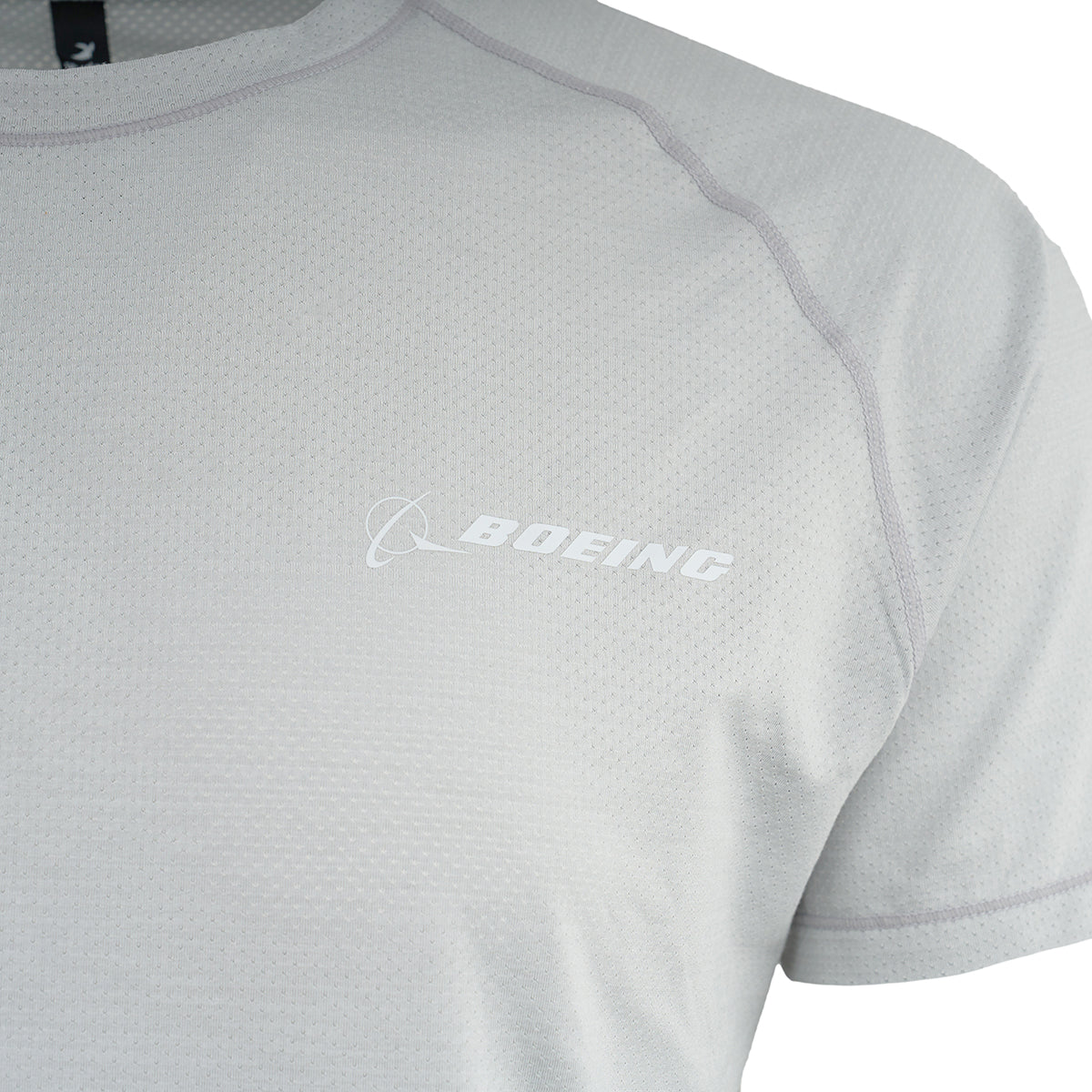 The Glyder Boeing Men’s Motivator T-Shirt by BOEING is a light gray athletic tee with white Boeing logo on the left chest, visible shoulder and sleeve stitching, and moisture-wicking fabric for breathable comfort during any activity.