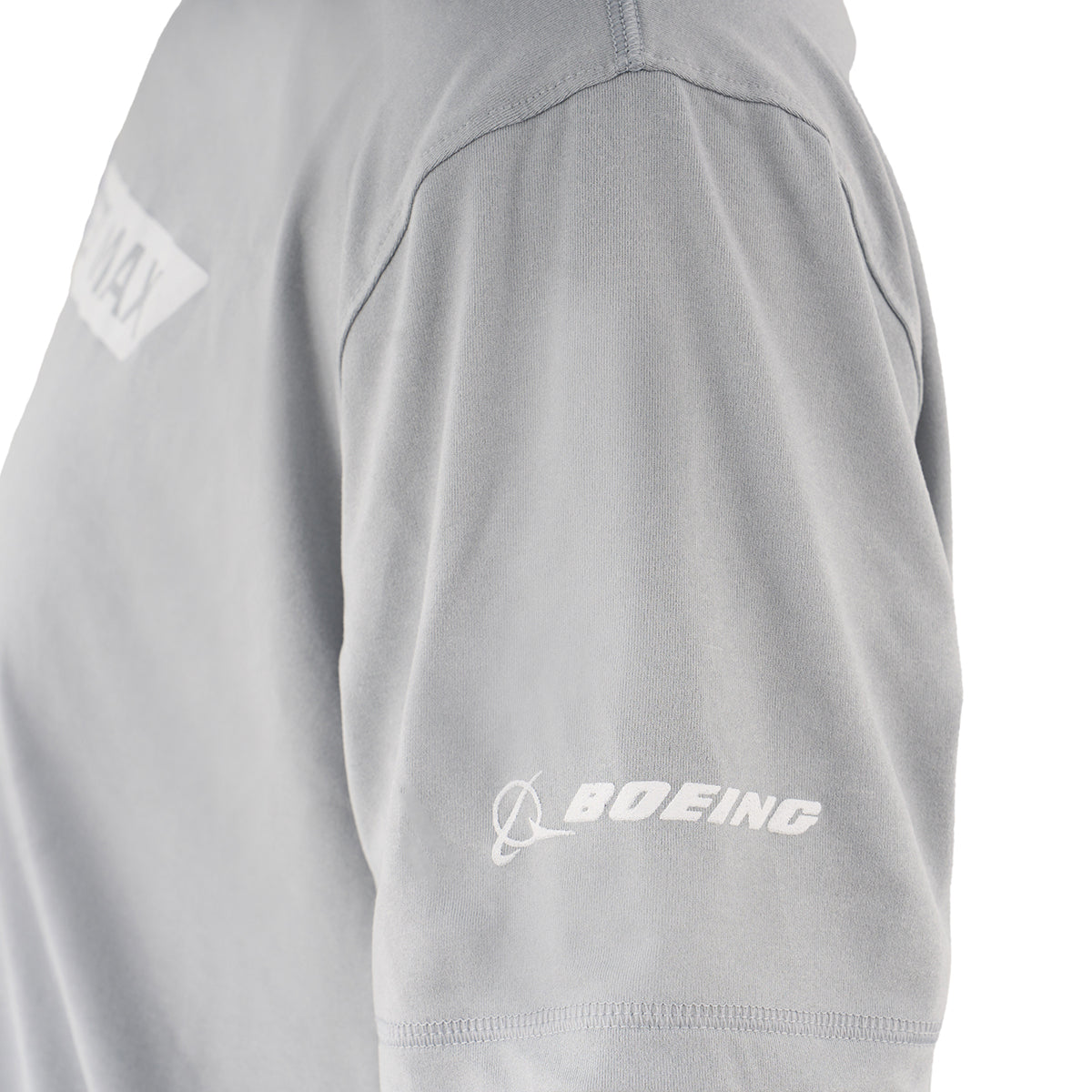Close-up of the Boeing 737 MAX Velocity Unisex Tech Stretch T-Shirt sleeve in light gray, featuring a white BOEING logo and emblem. The moisture-wicking fabric also displays part of a white rectangular chest graphic.