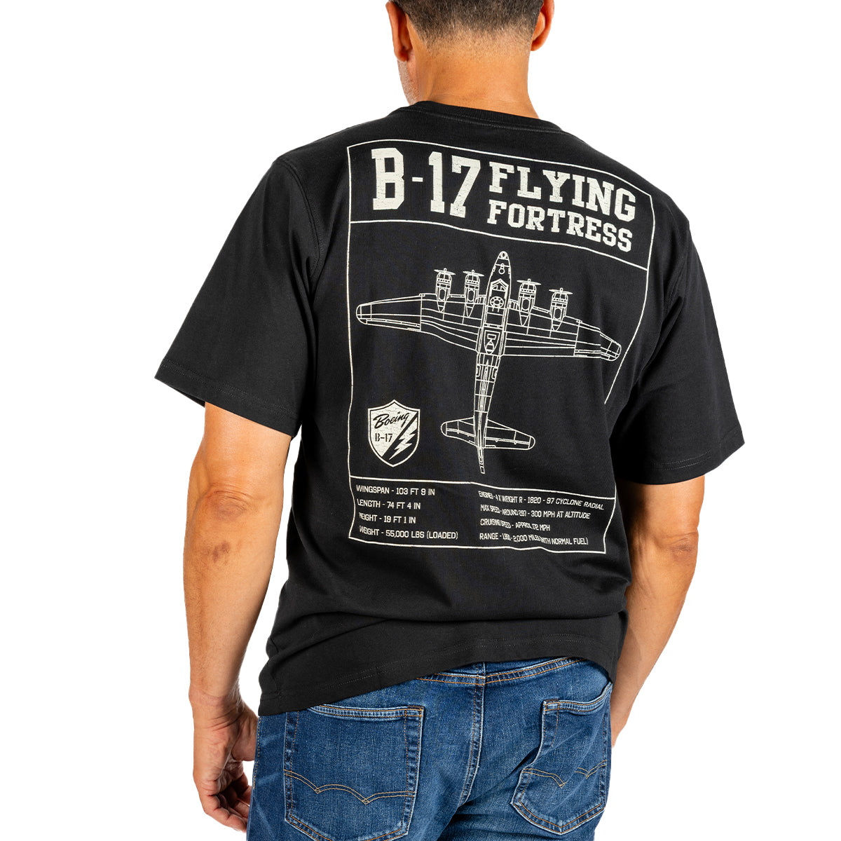 A man wears the Boeing Heritage Script B-17 Flying Fortress Unisex T-Shirt by BOEING, which features a bold white schematic graphic of the iconic Flying Fortress and its specifications on the back—a tribute to aviation history and Boeing’s legacy.