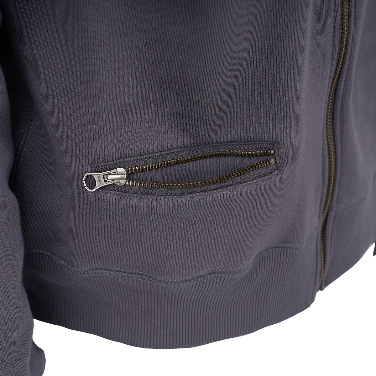 Close-up of The Boeing Store’s Red Canoe Boeing Airplane Logo Full Zip Sweatshirt in dark gray cotton poly fleece, with a small zippered pocket, front zipper, visible stitching, and ribbed hem.