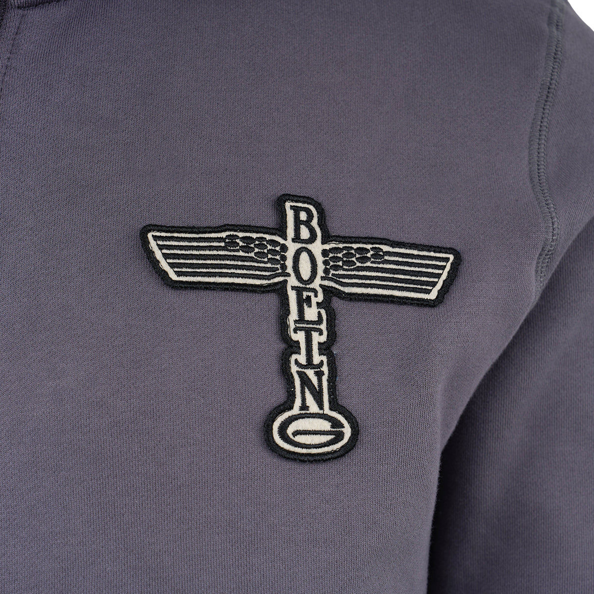 The Boeing Store’s Red Canoe Boeing Airplane Logo Full Zip Sweatshirt is a gray cotton poly fleece with an embroidered vertical “BOEING” patch and a winged airplane logo emblem.