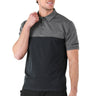 A man with short hair smiles, holding the collar of the Glyder Boeing Signature Halfway Polo by BOEING. The athletic polo features a retro color block design with a dark lower half, lighter gray marbled jersey upper half, and a logo on the left sleeve.