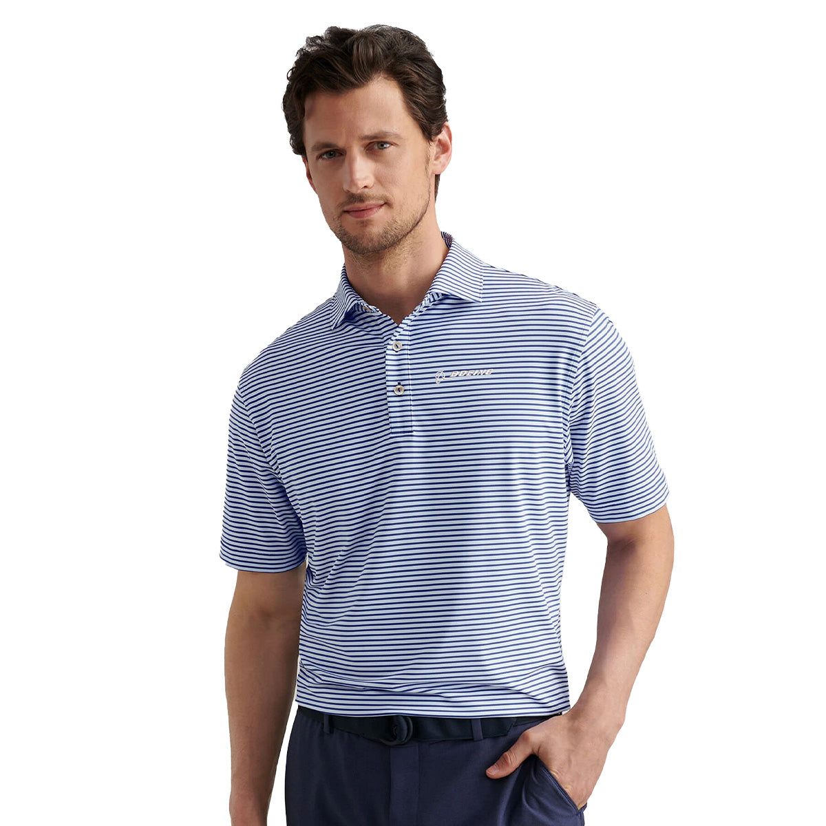 A man wearing a blue and white striped Peter Millar Boeing Men’s Culver Performance Polo by BOEING, with buttons, stands with one hand in his pocket looking at the camera.
