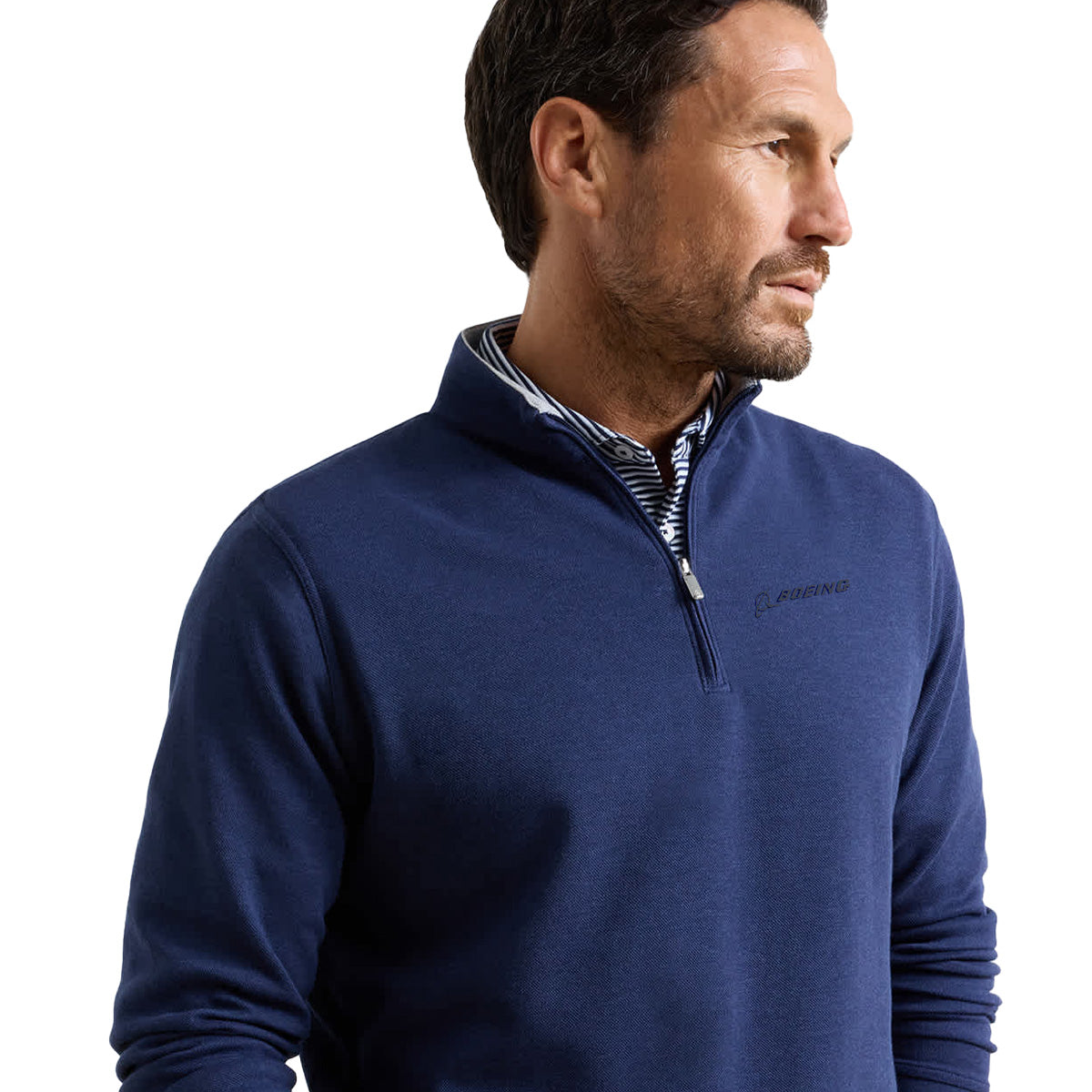 A man wearing the Peter Millar Boeing Men’s Crown Comfort Knit Quarter-Zip, layered over a collared shirt, stands facing right against a white background, with the subtle Boeing logo embroidered on the chest.