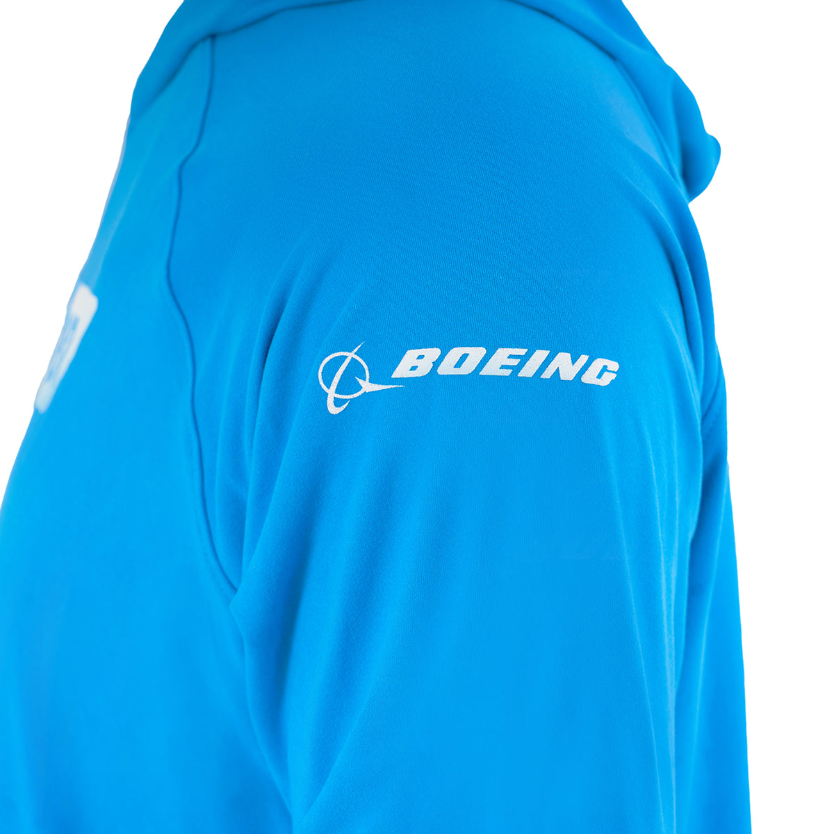 A close-up of a person in the Boeing 787 Dreamliner Velocity Unisex Tech Stretch Hoodie by BOEING, featuring a bright blue color, white Boeing sleeve logo, and high-performance fabric for an athletic fit.