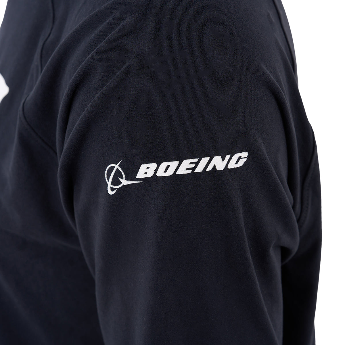 A close-up of a persons upper arm wearing the Boeing C-17 Globemaster Velocity Unisex Tech Stretch Hoodie by BOEING, featuring the white Boeing logo and text on the sleeve.