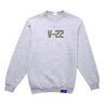 The Boeing V-22 Osprey Unisex Graphic Crewneck Sweatshirt by BOEING features olive green V-22 block letters on light gray and a small blue tag on the right hem—ideal for aviation fans.