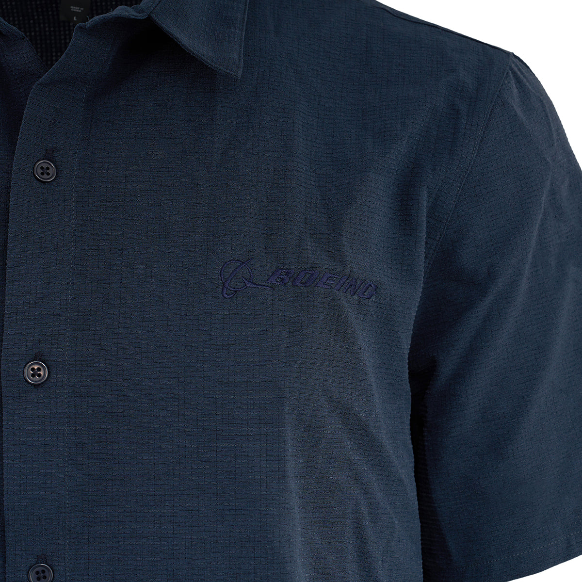 The Glyder Boeing Men’s Zephyr Shirt by BOEING is a classic navy blue short-sleeve button-up with the Boeing logo embroidered in blue on the left chest. Made from lightweight, stretch-woven fabric for all-day comfort.