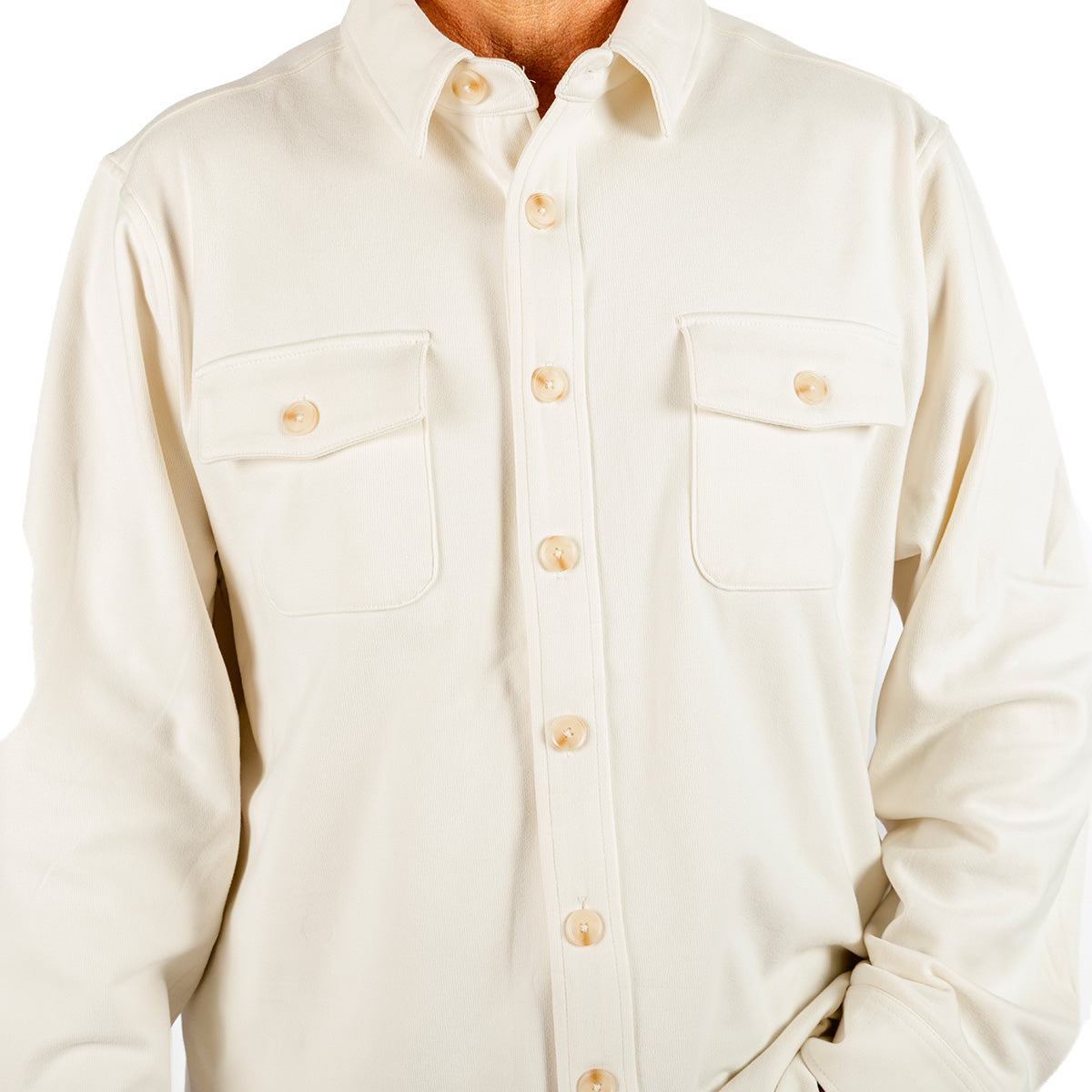 A person is wearing the Boeing Unisex Journey Overshirt by BOEING—a cream-colored, long-sleeve overshirt featuring two chest pockets—standing against a white background with only the upper torso visible.