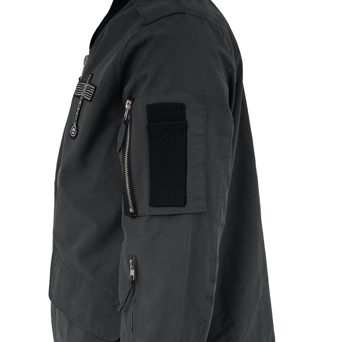 Side view of a dark green Red Canoe Boeing Flight Jacket by The Boeing Store, featuring zippered pockets, Velcro sleeve patch, and front chest zipper detail. Inspired by classic Boeing flight jacket style and worn by a person.