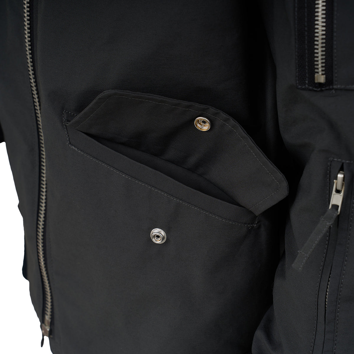 Close-up of The Boeing Store Red Canoe NASA Flight Jacket, showing an open side pocket with a snap button, a left zipper, and a right sleeve pocket with zipper.