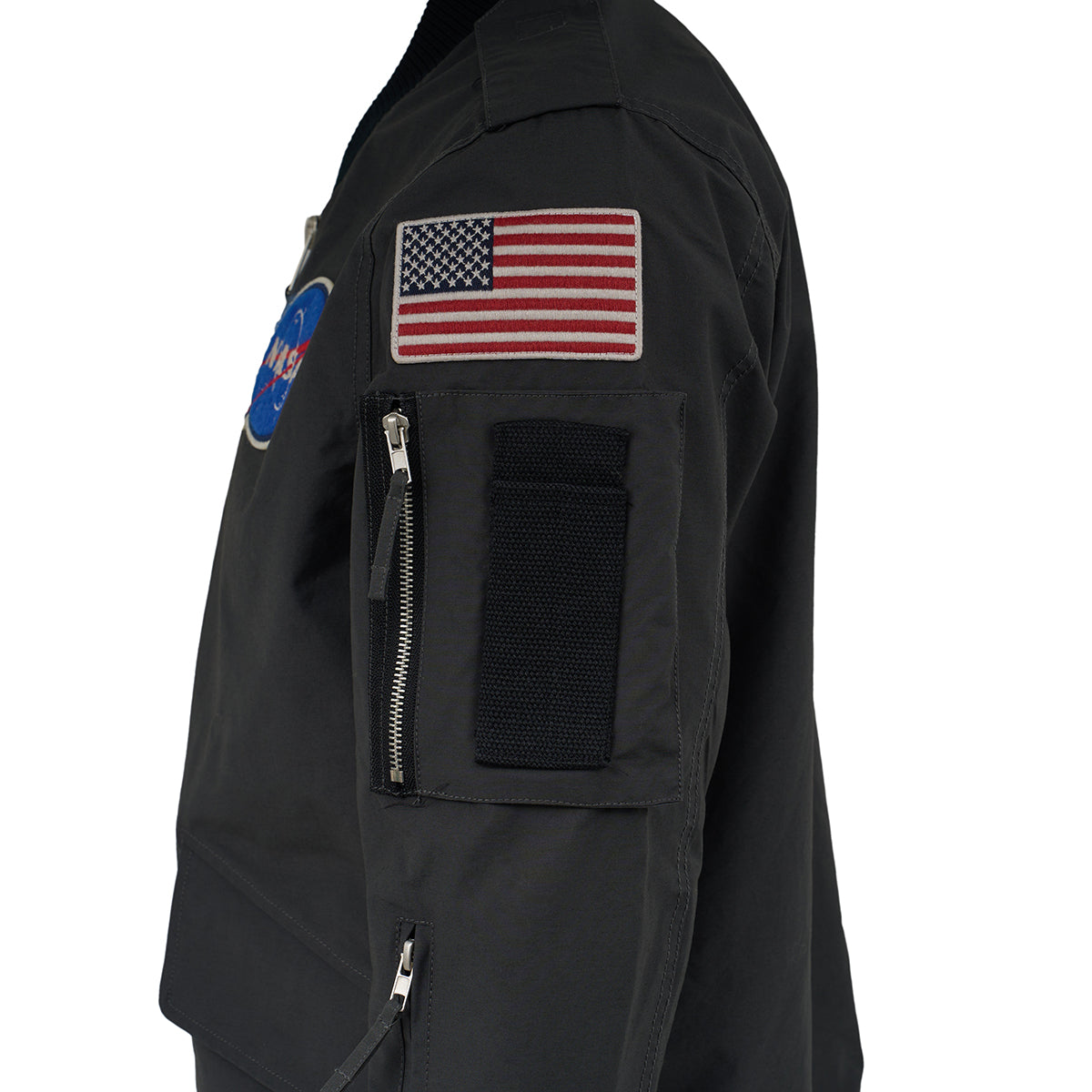 A close-up of The Boeing Store's Red Canoe NASA Flight Jacket, featuring NASA and US flag patches plus a zippered sleeve pocket with Velcro patch, set against a white background.