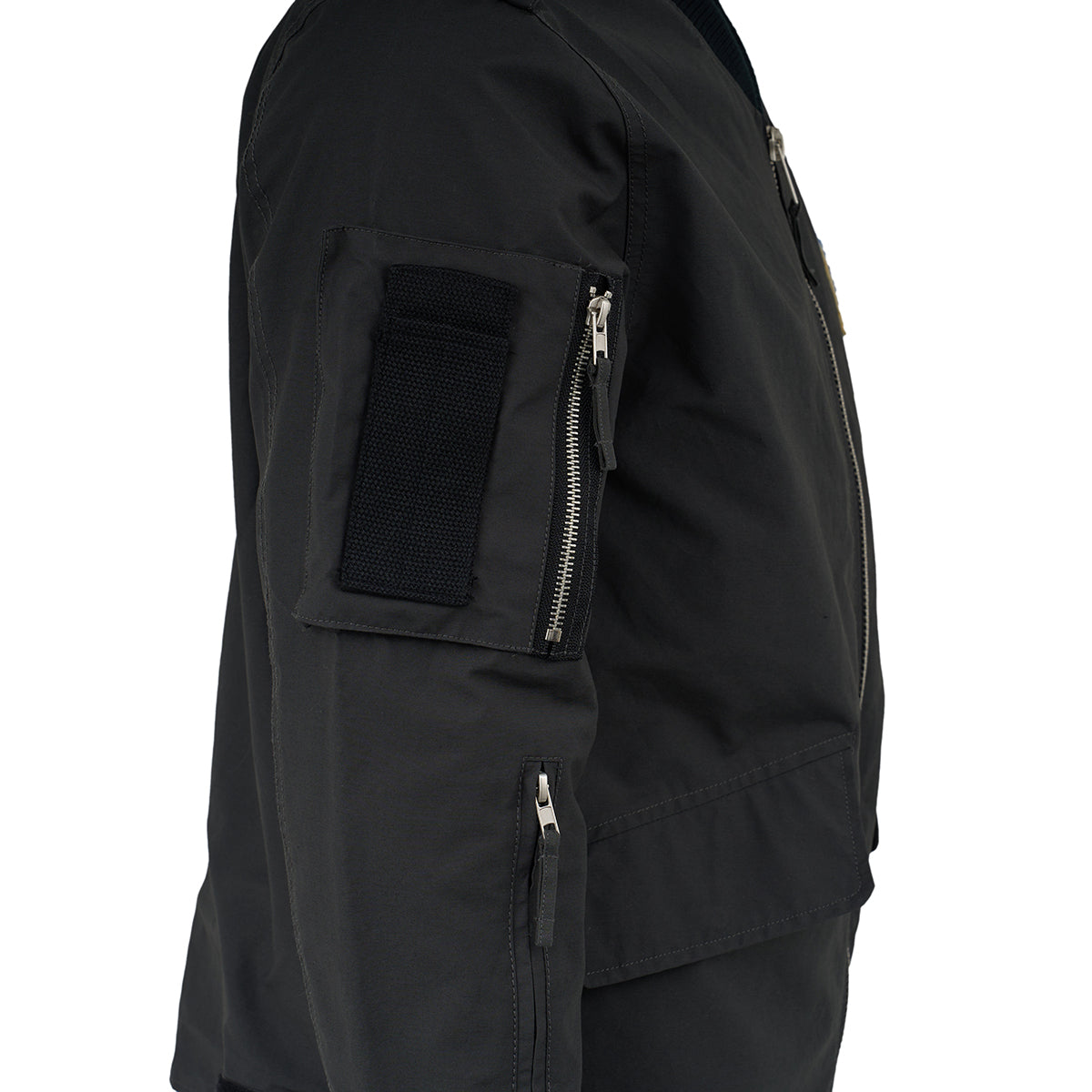 A close-up side view of The Boeing Store Red Canoe NASA Flight Jacket, featuring zippered sleeve and side pockets plus a black upper arm patch, set against a plain white background.