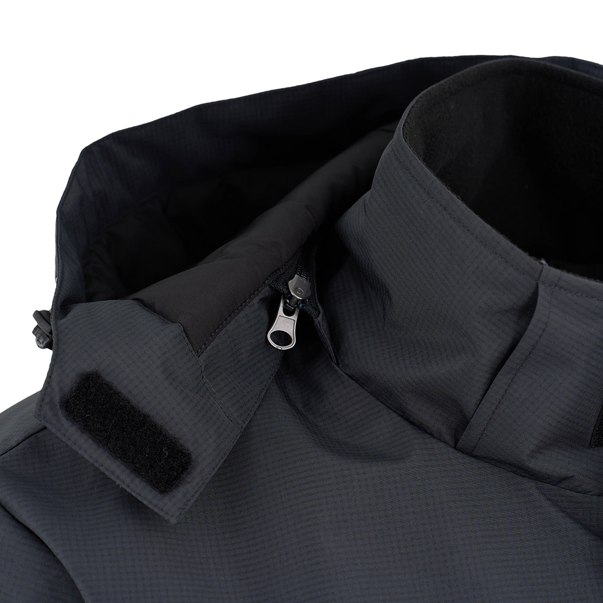 Close-up of the Boeing Men's Trifecta Ripstop Jacket by BOEING, featuring a water-resistant, dark gray ripstop fabric with subtle texture, shown with collar, attached hood, partially opened zipper, and Velcro patch.