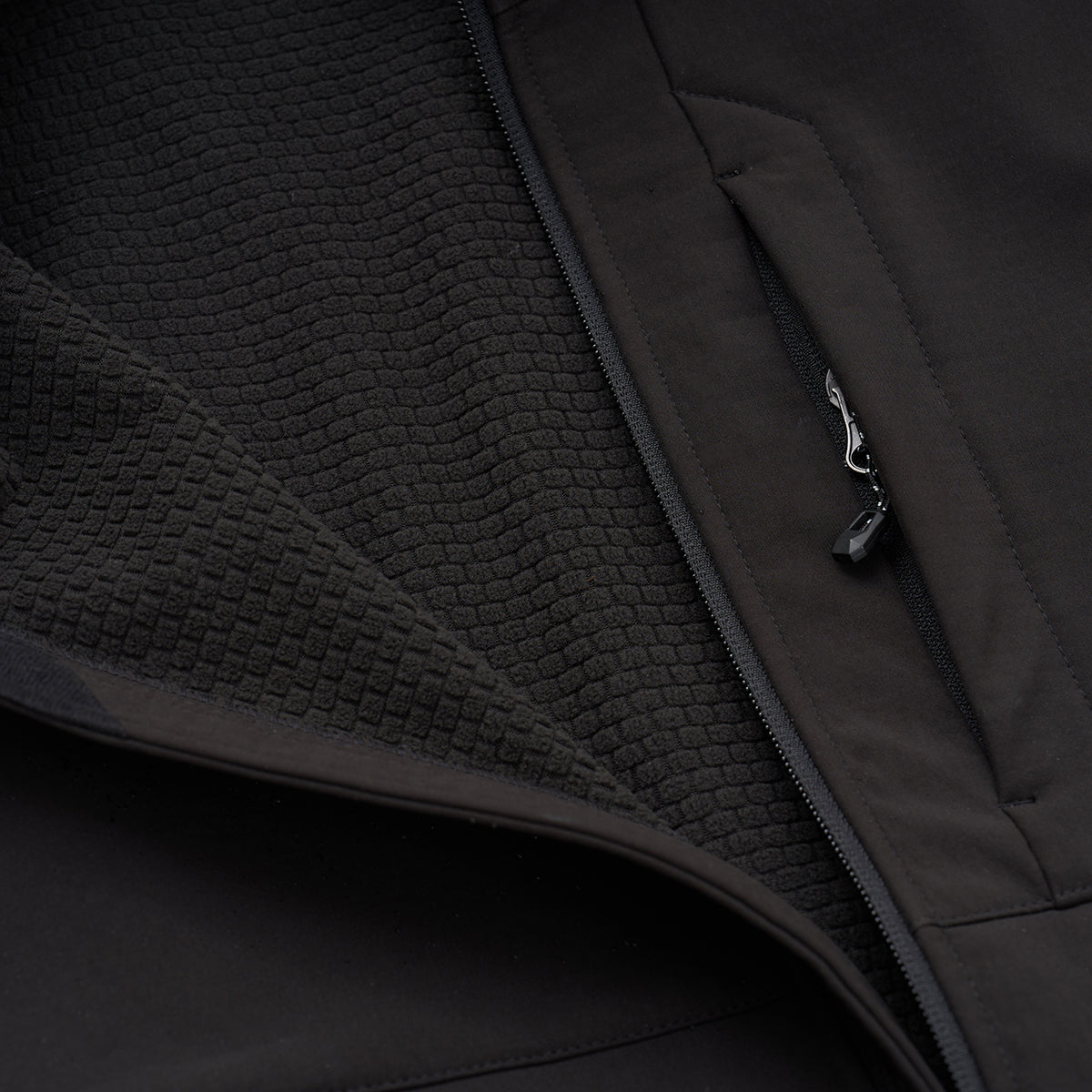 Close-up of the BOEING Men's Softshell Jacket features a textured inner lining and a zippered outer pocket with pull tab. The water-resistant jacket is partially unzipped to reveal intricate fabric details.