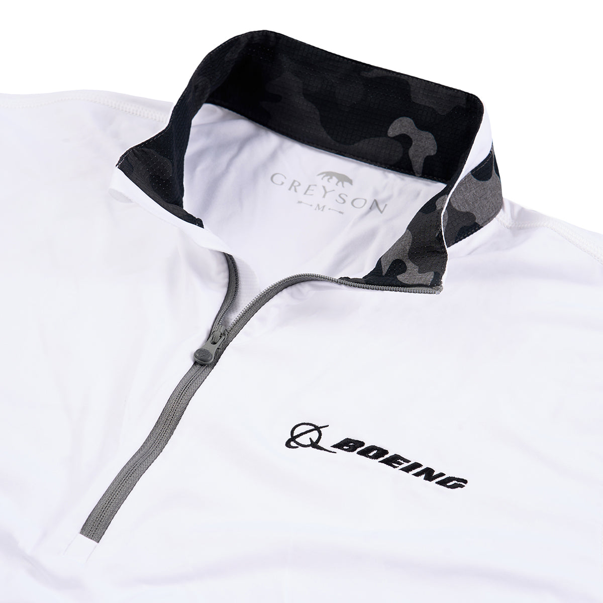 close up image of the black Boeing logo on left chest.  Grey zipper.  Grey camo pattern in collar.