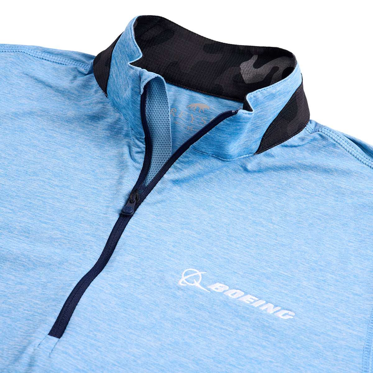 Close up image of the white Boeing logo on the blue quarter-zip.  Grey camo pattern on collar.