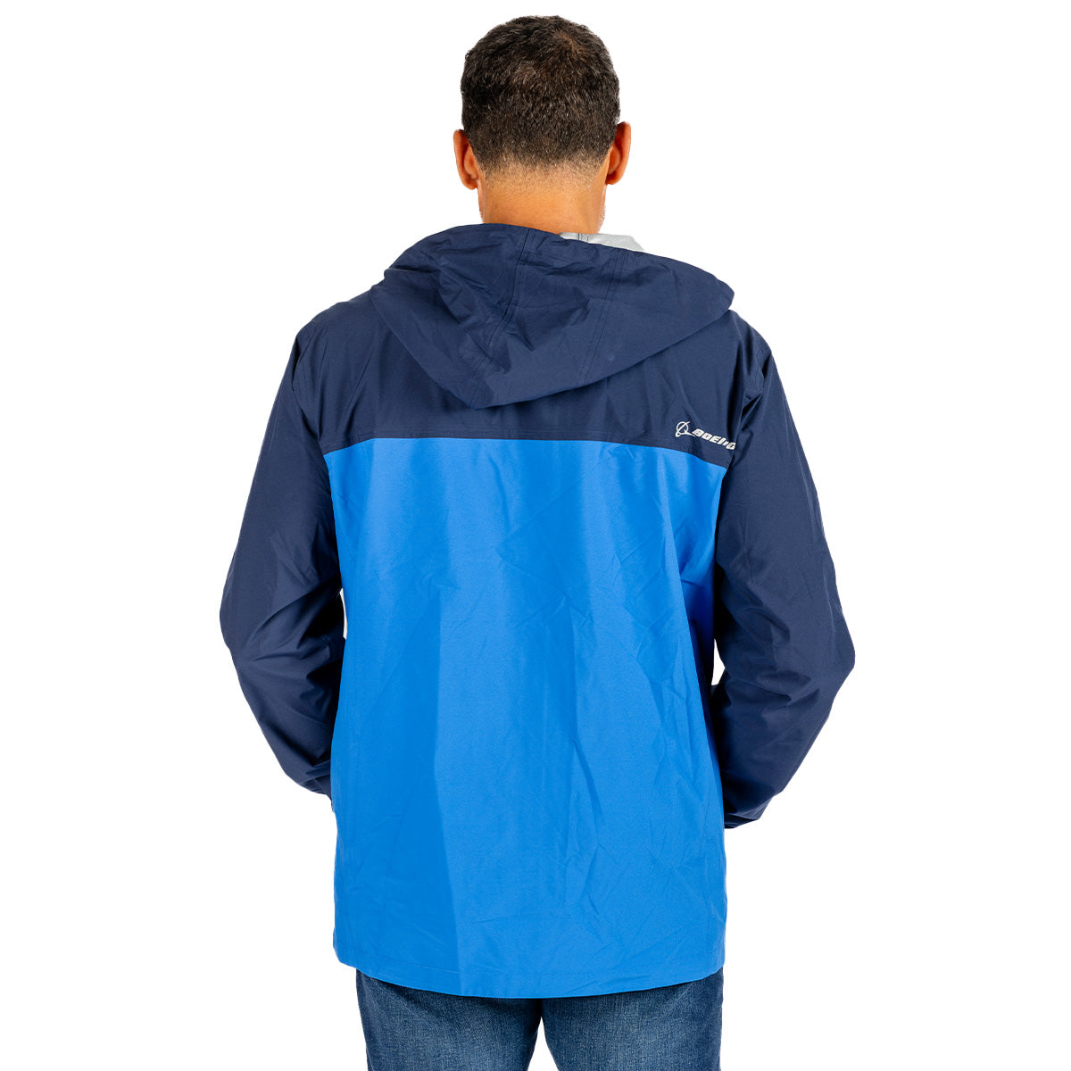 Back view of a person wearing a navy and blue Boeing Unisex Waterproof Rain Jacket with a small logo on the upper right chest.
