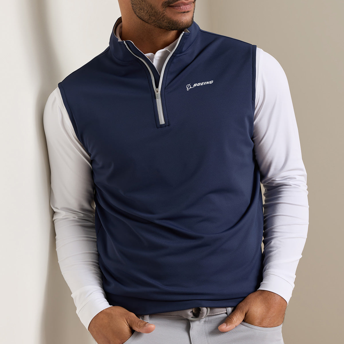 Man wearing a navy Quarter-Zip vest with white  zipper and white Boeing logo on the left chest.