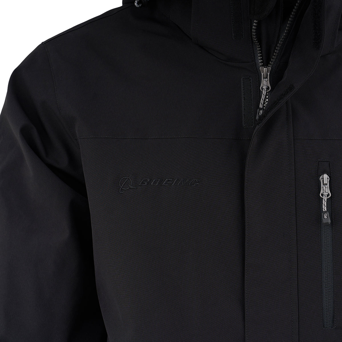 Close-up of the Boeing Men's 3-in-1 Systems Jacket: features a zipper, small chest pocket, and black-on-black BOEING logo embroidery on the left chest—combining style with weather protection.