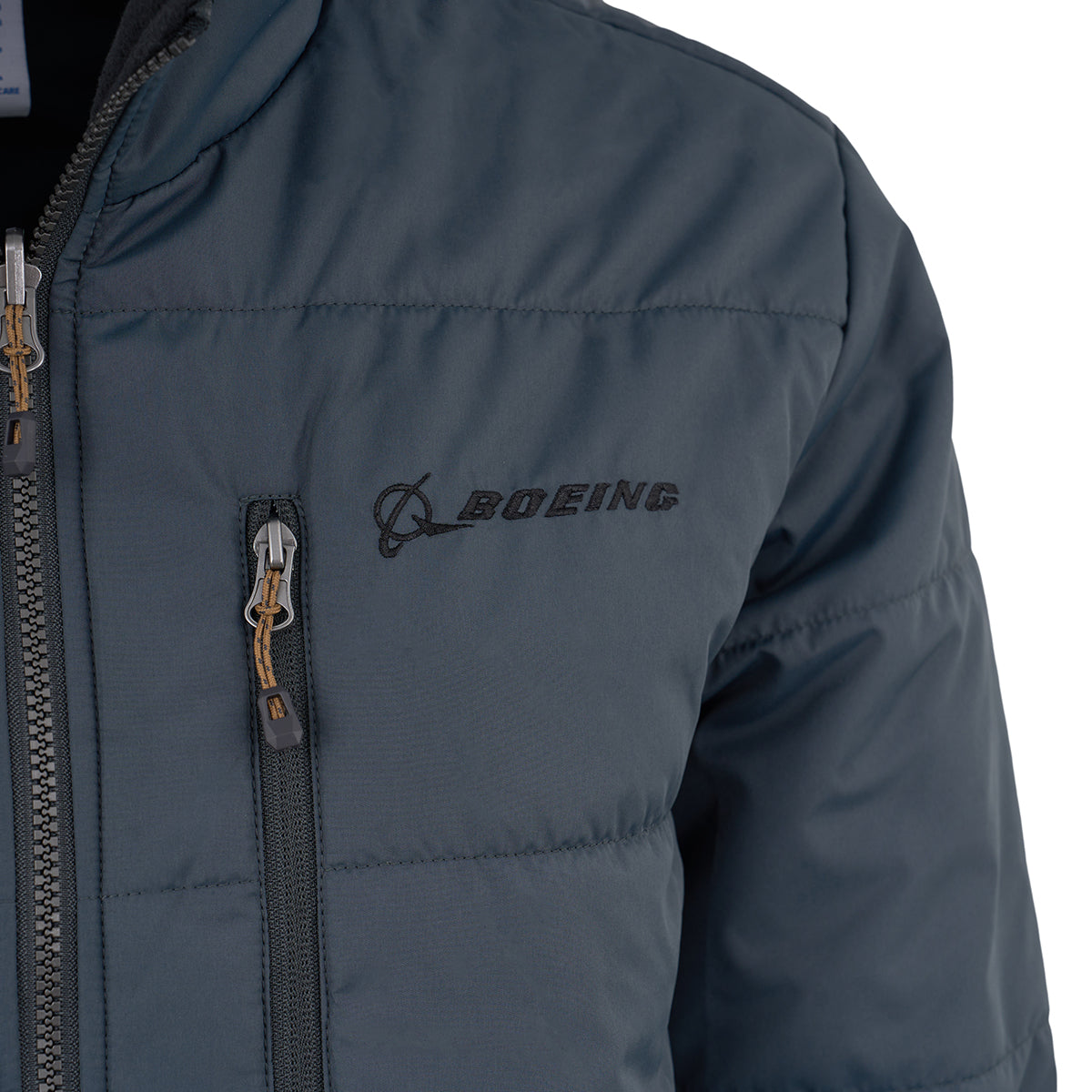 Close-up of the upper chest area of the Boeing Men's 3-in-1 Systems Jacket by BOEING, featuring a black embroidered logo and planet graphic above a vertical zippered pocket—versatile outerwear for weather protection.