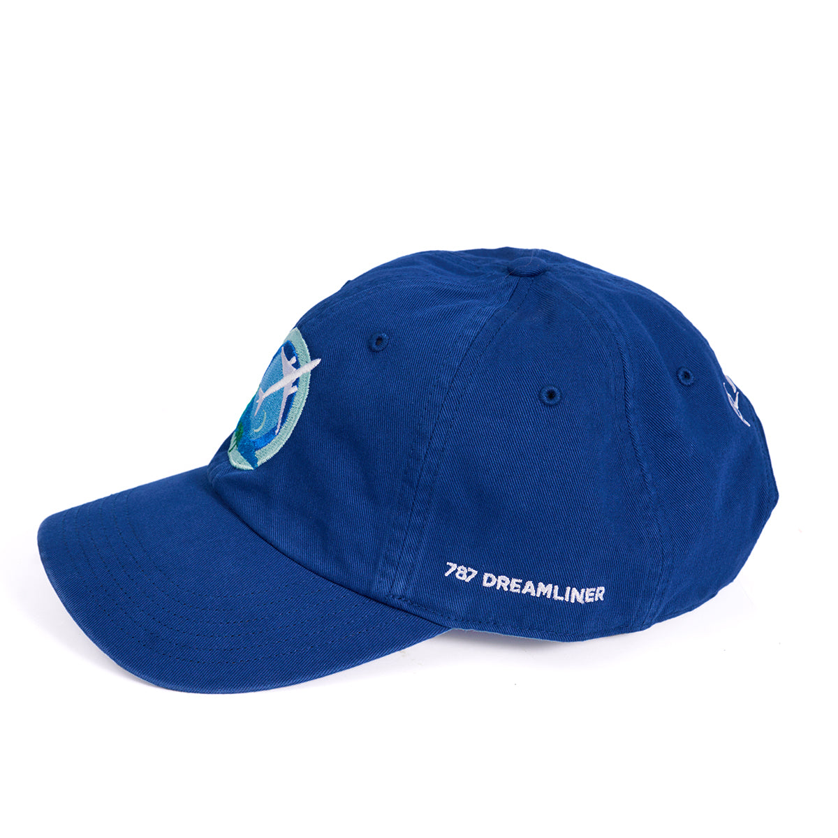 The Boeing 787 Dreamliner Skyward Hat by Boeing is a blue baseball cap with an embroidered stylized 7 and 8 logo on the front. 787 Dreamliner is stitched in white on the side. It features ventilation eyelets and an adjustable back strap.