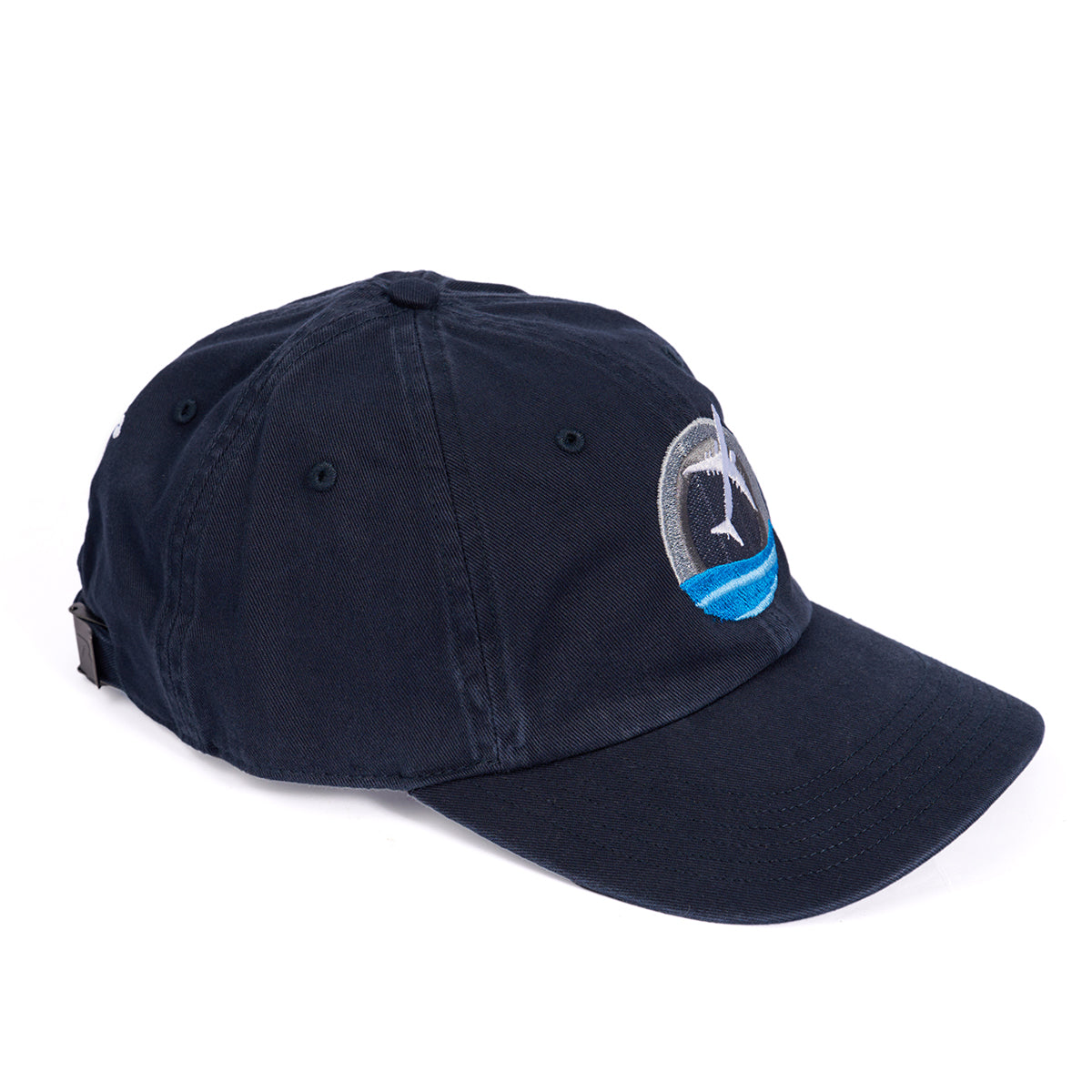 The Boeing P-8 Poseidon Skyward Hat by Boeing is navy blue with a curved brim, an adjustable backstrap, and features an embroidered logo of a leaping fish over a blue wave against a gray circular background.
