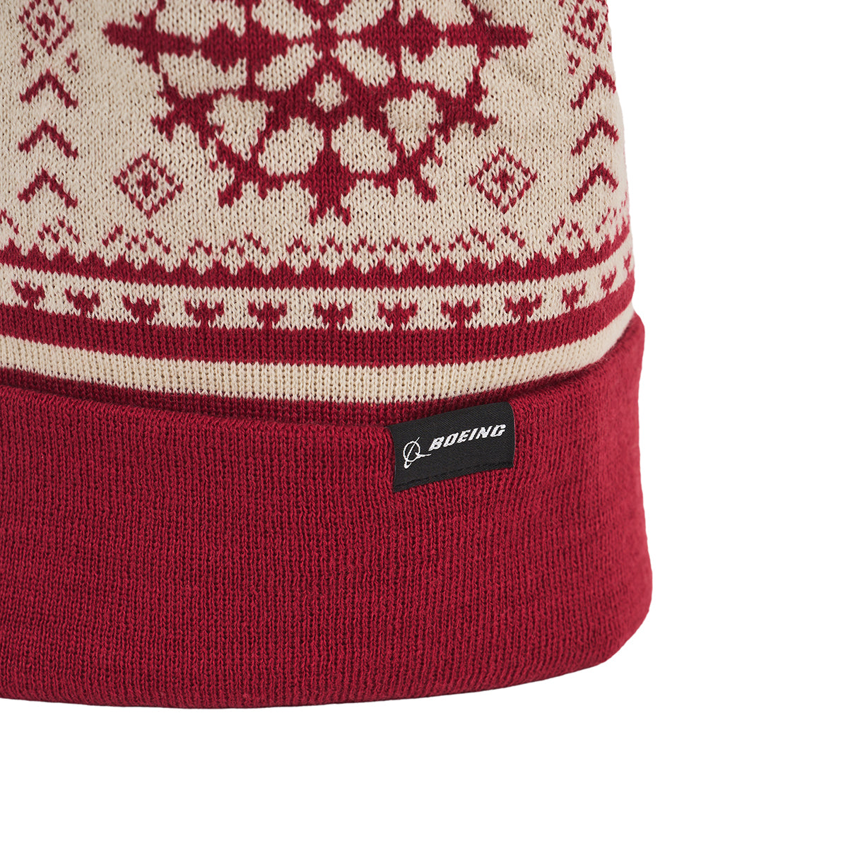 The Boeing 2025 Jet Snowflake Unisex Beanie features a red and beige knit, snowflake pattern, and black tag with the BOEING logo on the brim—pair it with the Jet Snowflake Scarf for cozy 787 Dreamliner-inspired style.