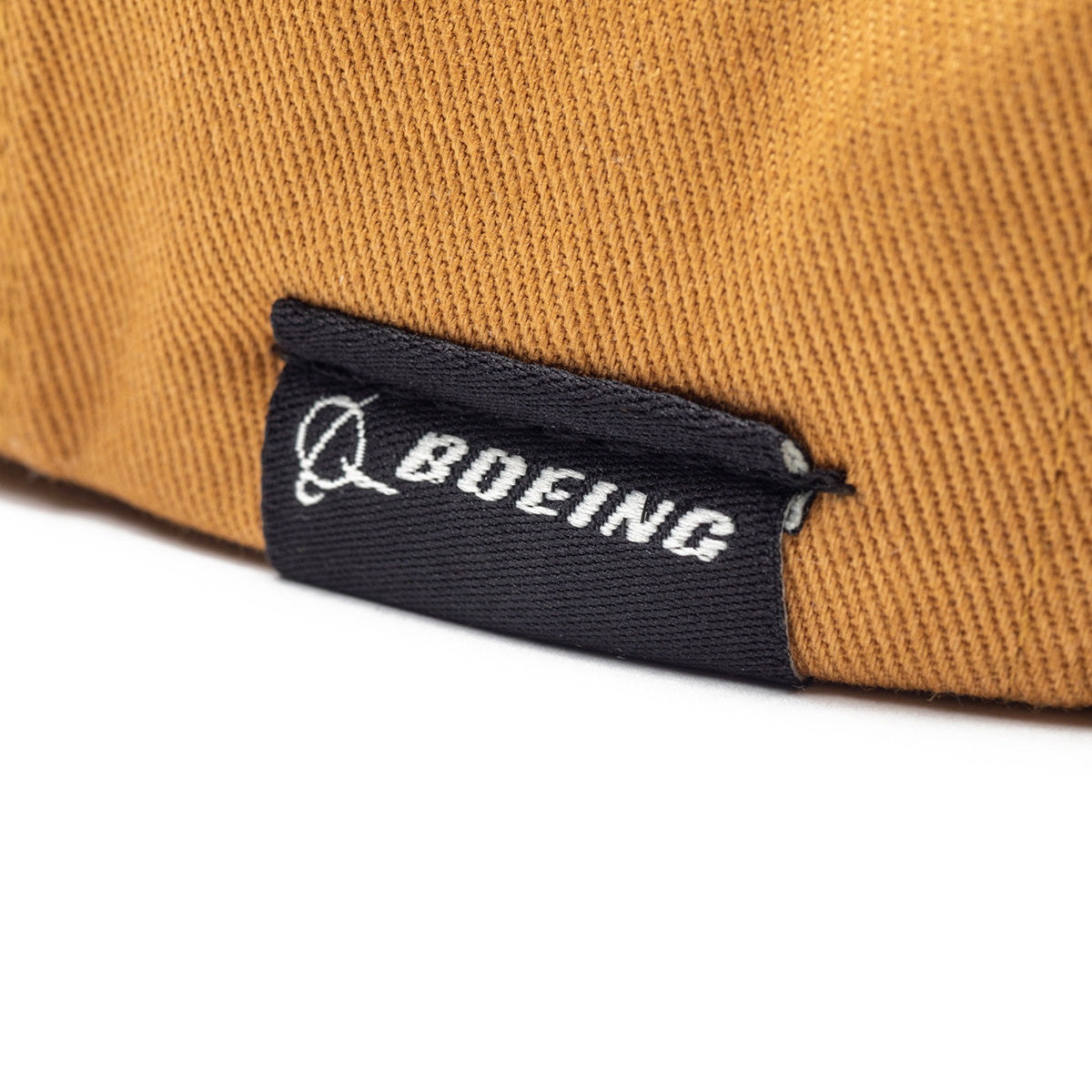 A close-up of the black fabric tag with the white BOEING Airplane logo, sewn onto a brown Richardson Boeing Airplane Logo Snapback Hat—ideal for aviation heritage and snapback fans.