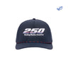 The Boeing America 250 Performance Hat by BOEING is a navy blue cap made from recycled polyester, featuring "250 Boeing Backs America" embroidered in white with colorful lines and a blue and white leaf logo on the top right.