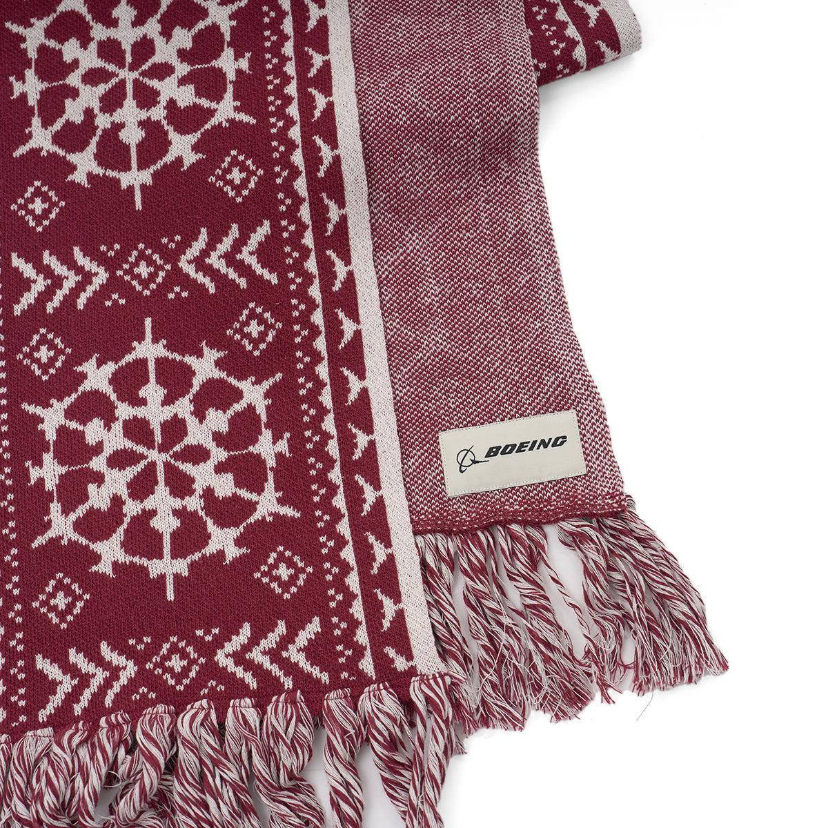 The Boeing 2025 Jet Snowflake Unisex Scarf features maroon and white snowflake and chevron patterns, fringed edges, and a sewn Boeing logo tag—perfect for any 787 Dreamliner enthusiast.