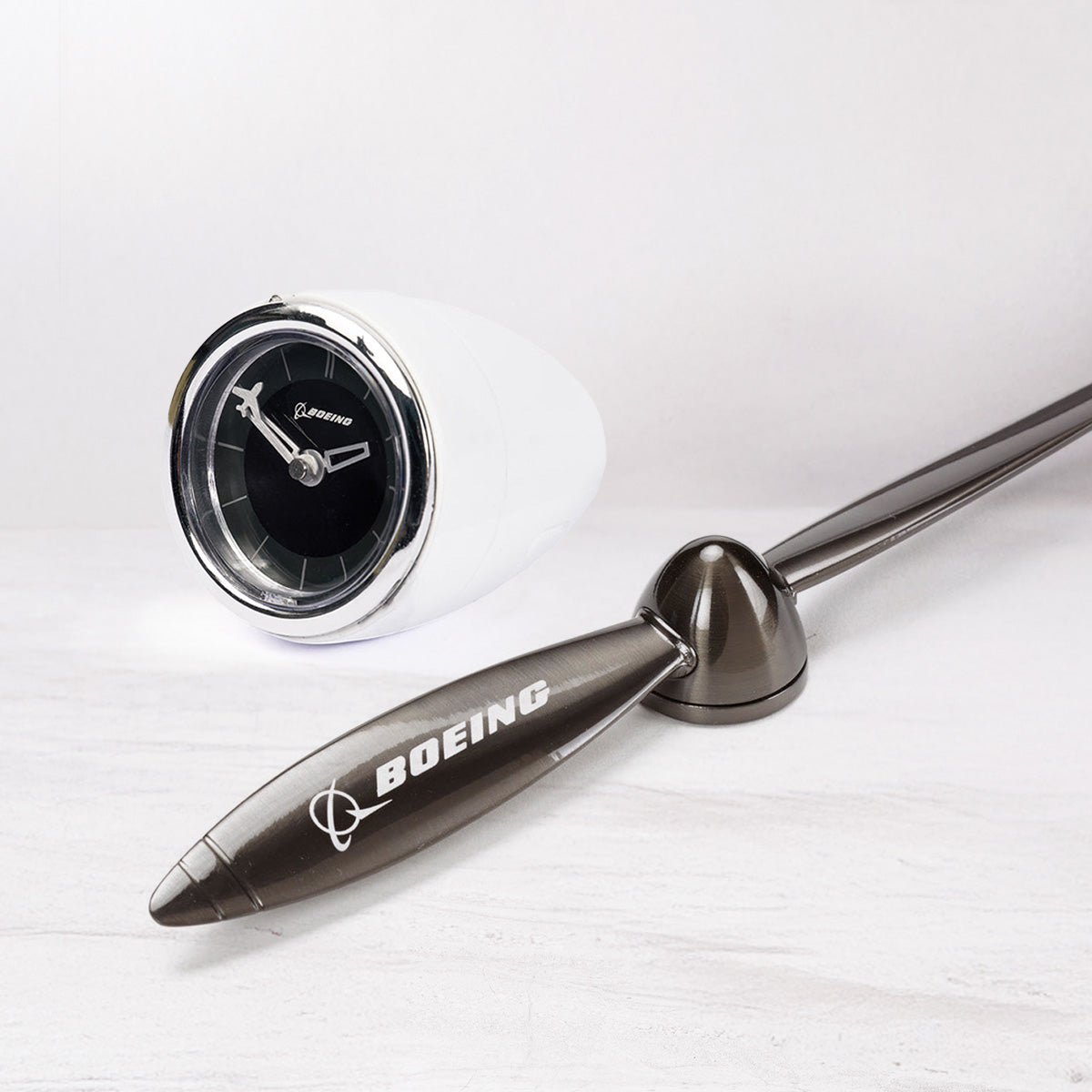 Boeing desk clock and propeller letter opener against a pale grey background