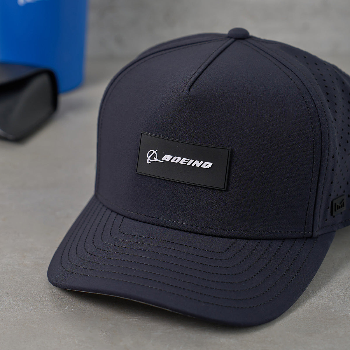 Navy blue cap with Boeing logo on a gray surface