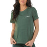 A woman wears the Glyder Boeing Women’s No Harm T-Shirt—a green, soft organic cotton crew-neck by BOEING, with the brand's name and logo in white on the left chest—standing against a plain white background.